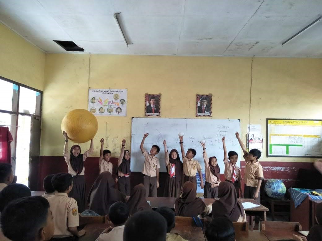 Siswa kelas 5 SD Merdeka memperlihatkan kepada teman sekelasnya, bagaimana ukuran Bumi dan planet-planet lainnya dibandingkan dengan Matahari.